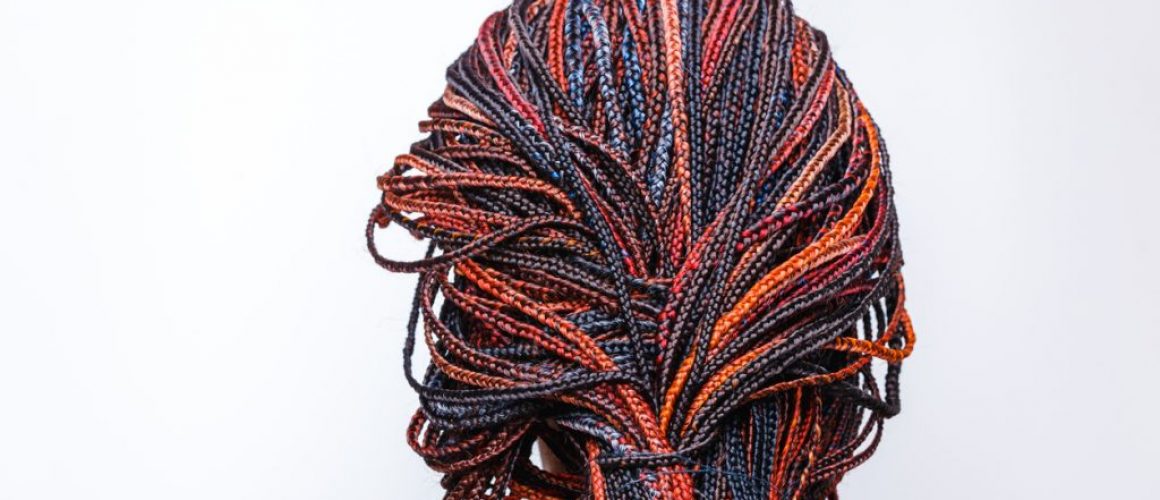 Close-up of afro pigtails braids in Zizi and Kanekalon technique with multi-colored threads and dreadlocks